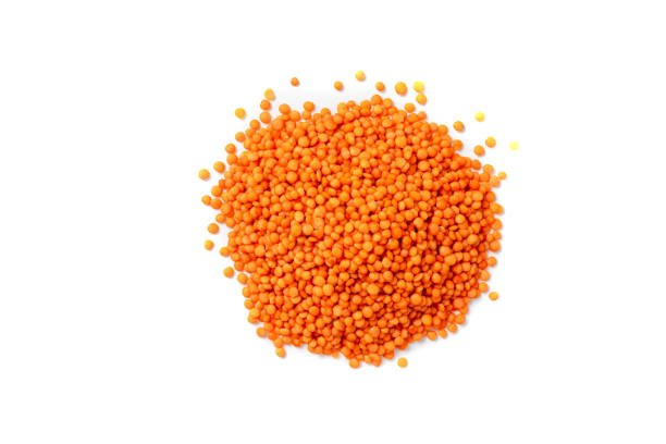 Dry red lentils on a white background isolate. Red lentil grits. Red lentils pile isolated. Dry orange lentil grains, heap of dal, raw daal, dhal, masoor, Lens culinaris or Lens esculenta on white background